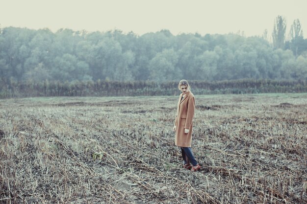 Une fille blonde marche seule sur le terrain vague. Le concept de dépression