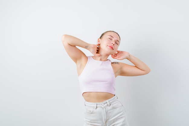 La fille blonde montre la pose de repos sur le fond blanc