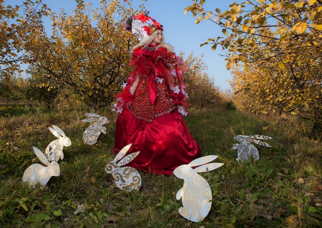 Fille blonde sensuelle dans la stylisation de conte de fées rouge fantastique dans apple park.