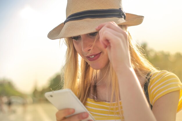 Fille blonde vérifiant son téléphone