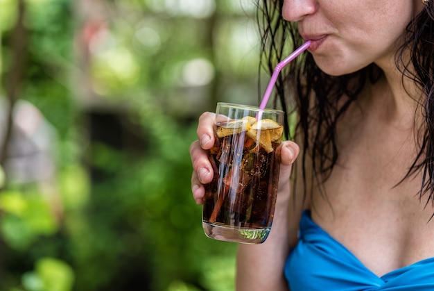 Une fille boit un cocktail à l'extérieur