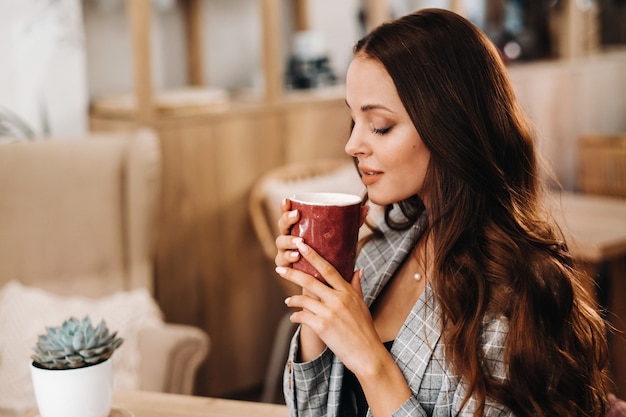 Une fille boit du café dans un café, de beaux cheveux d'une fille.