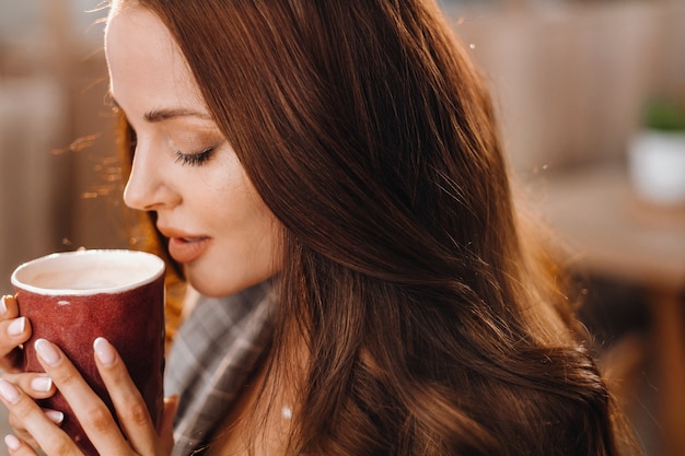 Une fille boit du café dans un café, de beaux cheveux d'une fille.