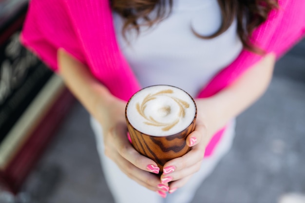 La fille boit du café Fille tenant du café dans ses mains Délicieux cappuccino dans les mains d'une fille Café et cappuccino à la main Bonjour Café délicieux