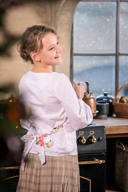 Fille boit du thé dans la cuisine à la maison