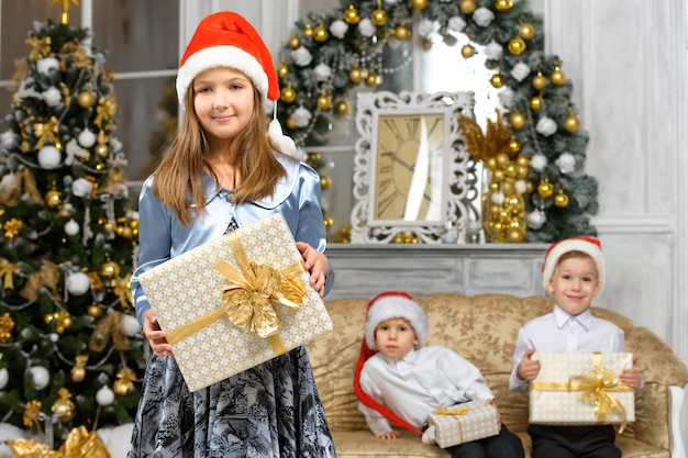 Fille avec boîte-cadeau de Noël et enfants souriants