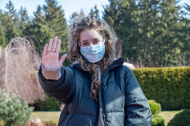 Photo fille en bonne santé dans un masque de protection médical montrant l'arrêt du geste.