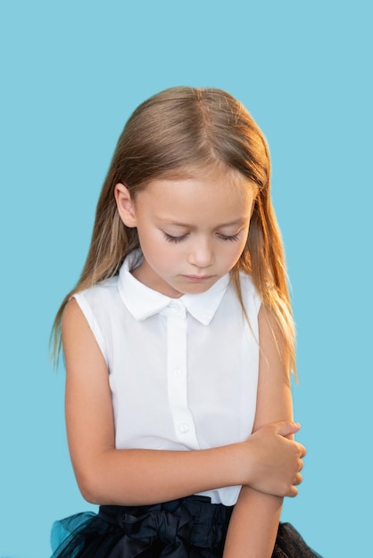 Fille bouleversée Enfants punition Erreur regret Portrait d'un petit enfant triste honteux en tenue élégante regardant vers le bas isolé sur fond bleu