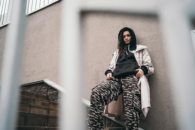 Photo une fille bouleversée se tient contre un mur dans la rue une fille dans un espace à capuche noir pour le texte un adolescent...