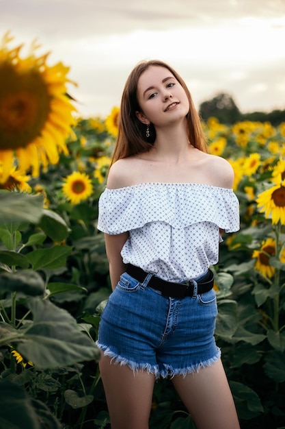 Fille avec bouquet jaune de champ de tournesol en fleurs