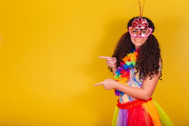 Fille brésilienne caucasienne habillée pour le carnaval bienvenue pointant vers le côté négatif présentant le produit