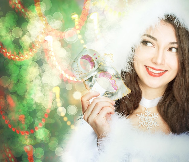 Fille brune de beauté en bonnet de noel près de l'arbre de Noël