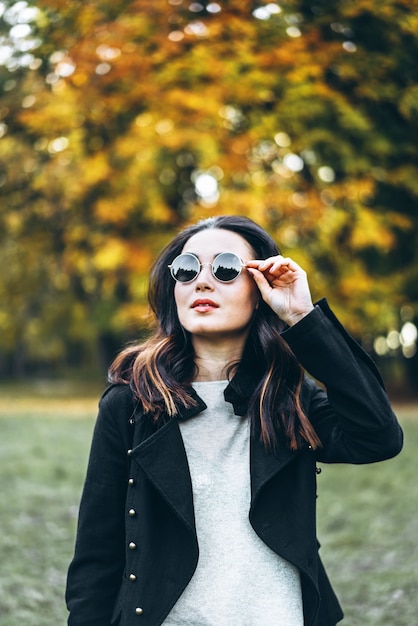 Fille brune cheveux longs se détendre dans le parc