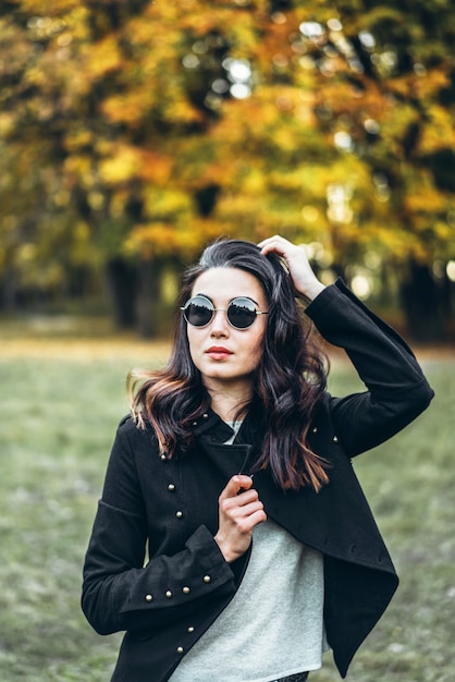 Fille brune cheveux longs se détendre dans le parc