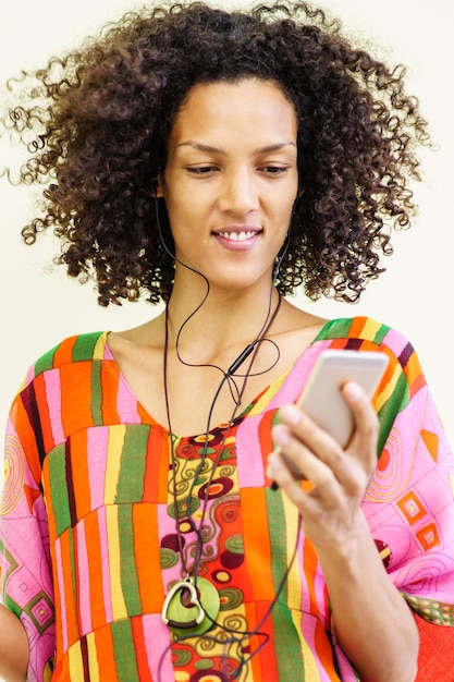 Fille brune écoutant de la musique avec son téléphone portable