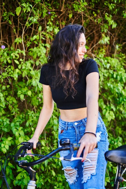 Fille brune faisant du vélo dans la ville