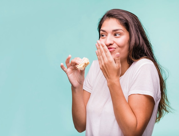 Fille brune manger de la pâtisserie