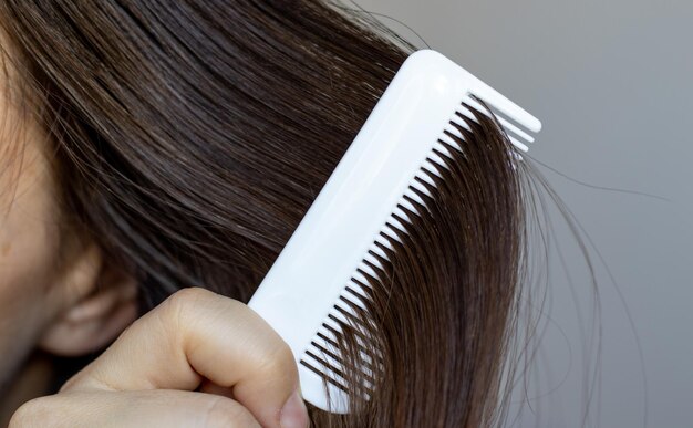 fille brune peigne ses cheveux avec un concept de coiffure de salon de beauté peigne blanc