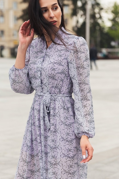 fille brune posant dans la rue de la ville Jolie belle femme d'affaires en fond de ville robe élégante