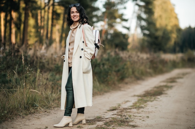 fille brune avec sac à dos sur le chemin de la forêt