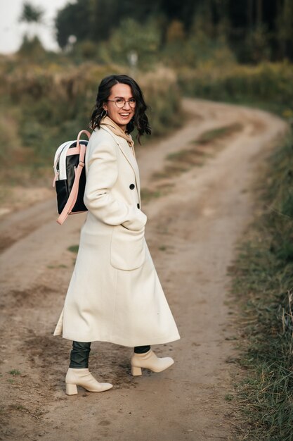 fille brune avec sac à dos sur le chemin de la forêt