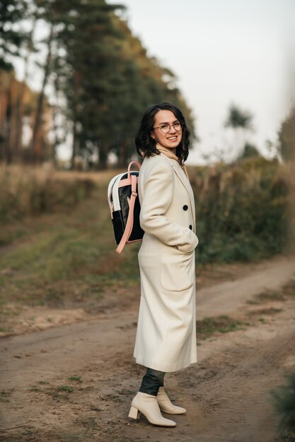 fille brune avec sac à dos sur le chemin de la forêt