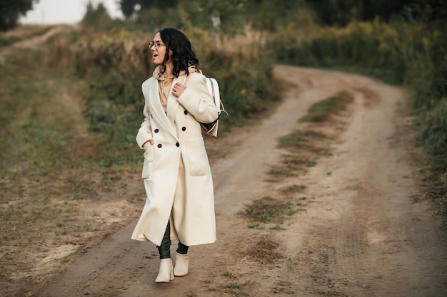 fille brune avec sac à dos sur le chemin de la forêt