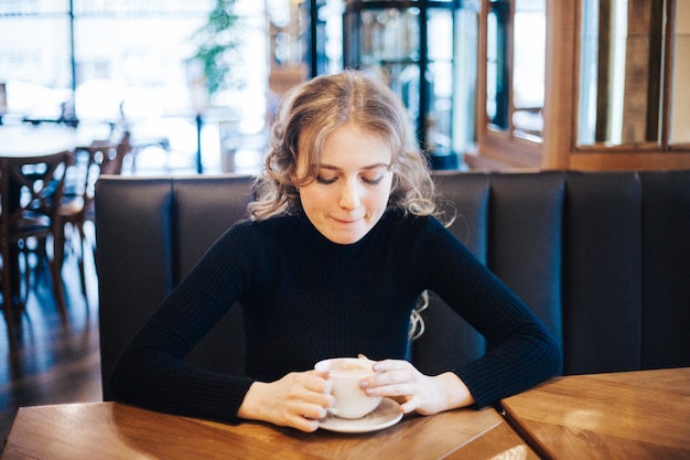 Fille buvant du café au café