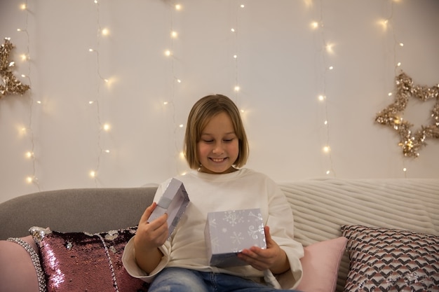 Fille avec un cadeau sur le canapé