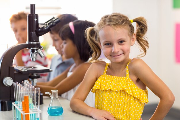 Fille avec des camarades de classe en laboratoire