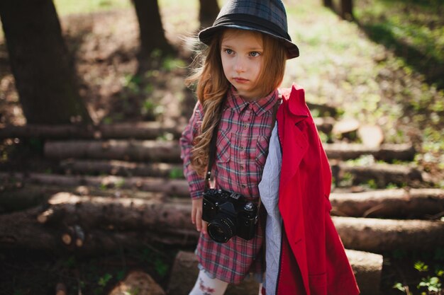 Fille avec caméra près de bois