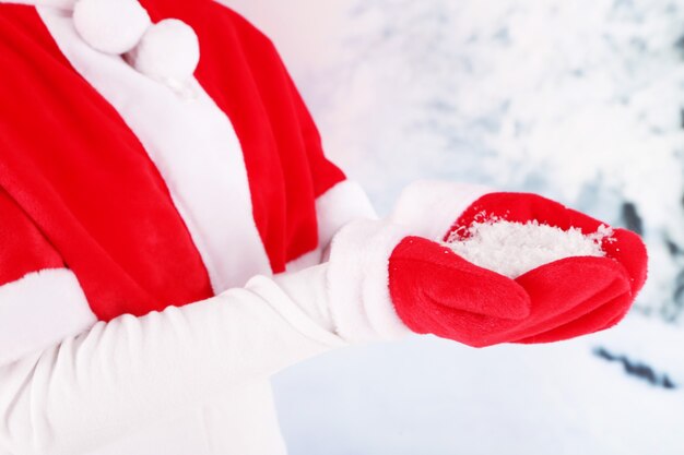 Fille en cape et gants rouges de Noël, sur fond d'hiver