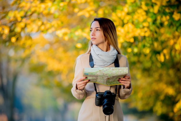 Fille avec carte et caméra à la recherche de chemin dans la rue.