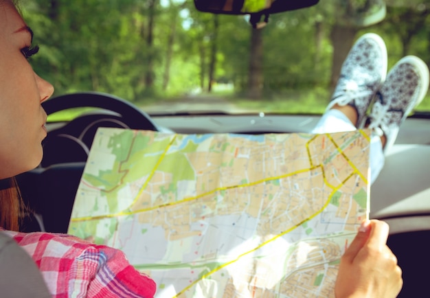 Photo fille avec une carte dans ses mains dans la voiture