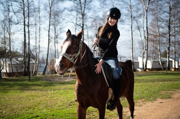 Fille avec casque à cheval dans la forêt