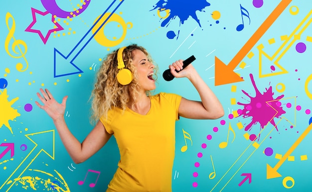 Fille avec casque écoute de la musique et des chansons avec microphone. expression émotionnelle et énergétique.