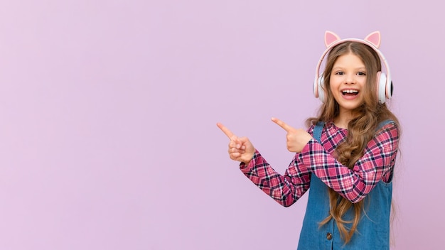 Une fille avec un casque pointe votre annonce sur un fond isolé