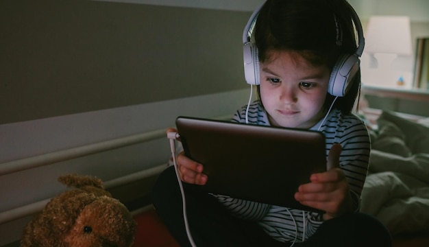 Fille avec un casque en regardant la tablette