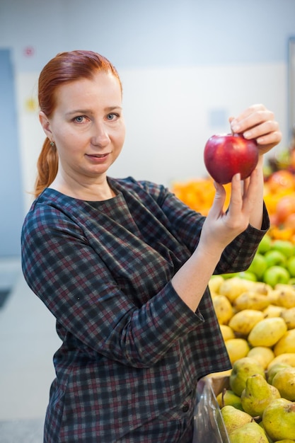 Fille caucasienne achetant des produits alimentaires de légumes frais au marchéxA
