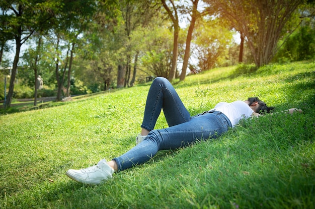 Fille caucasienne allongée sur l'herbe à l'extérieur