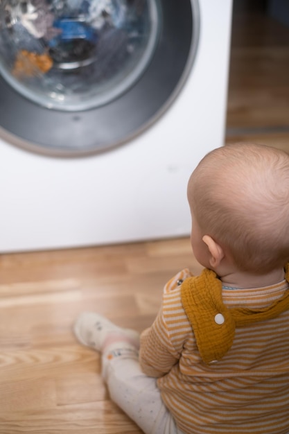 Fille caucasienne jouant avec une machine à laver regardant sur un processus