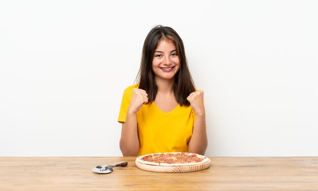 Fille caucasienne avec une pizza célébrant une victoire