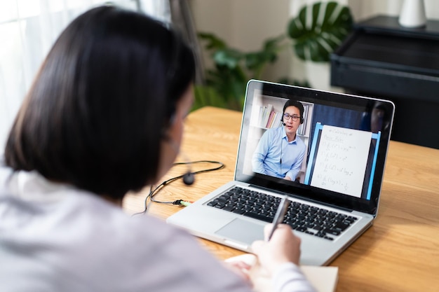 Une fille caucasienne qui apprend en ligne par vidéoconférence