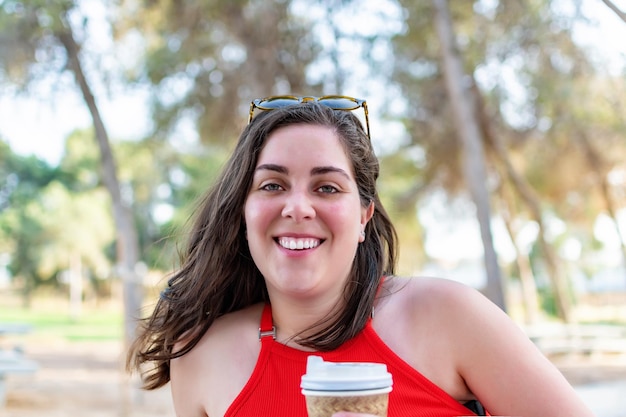 Fille caucasienne souriant dans le parc et regardant la caméra