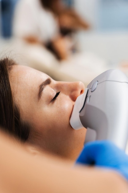 Une fille caucasienne subit un lifting facial non chirurgical dans une clinique de cosmétique.