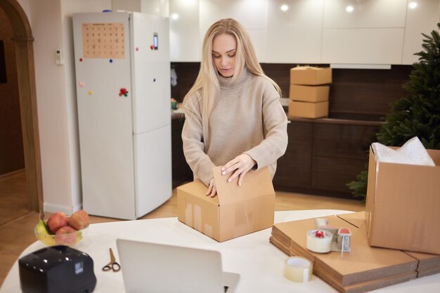 Fille caucasienne tapant des boîtes pour emménager dans un nouvel appartement