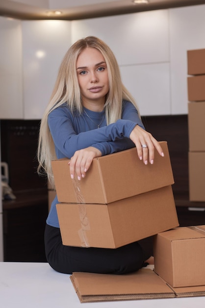 Fille caucasienne tapant des boîtes pour emménager dans un nouvel appartement