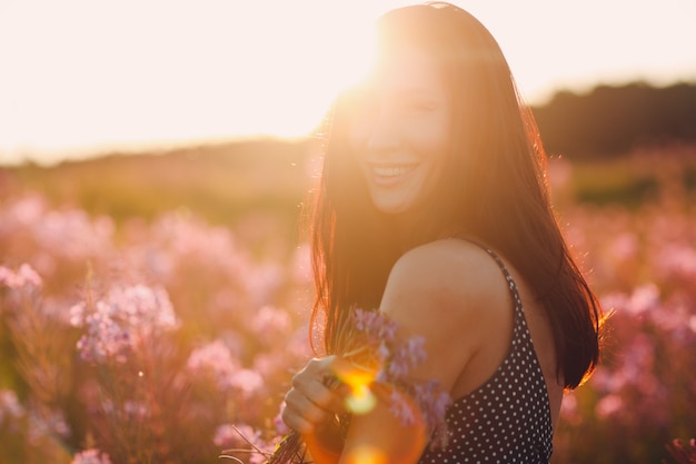 Fille sur le champ de fleurs Sally en fleurs. Fleurs et femme lilas