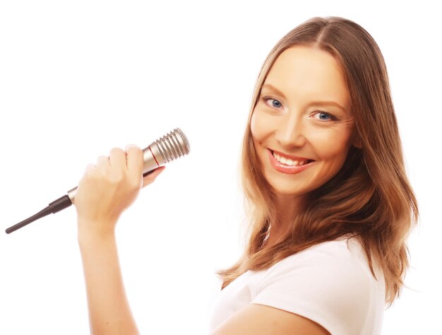 Fille de chant heureuse femme de beauté portant un t-shirt blanc avec un microphone sur fond blanc