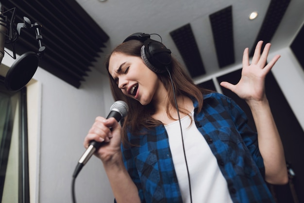 La fille chante sa chanson dans un studio d&#39;enregistrement moderne